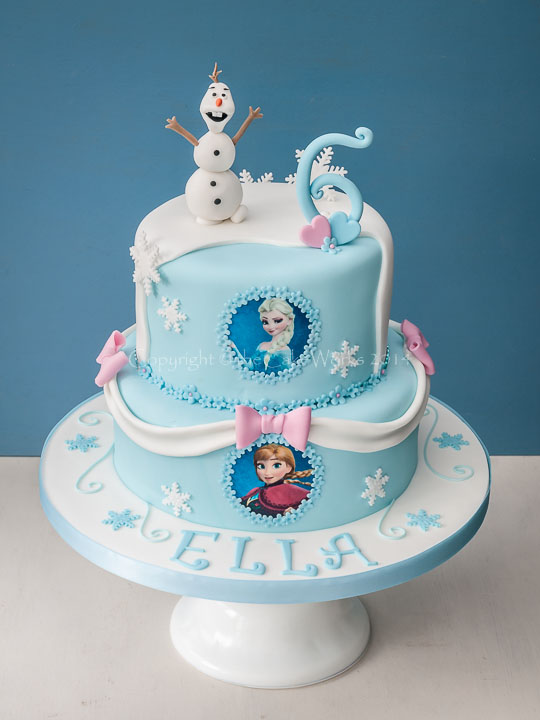 Two tier birthday cake with Olaf, Elsa and Anna characters fro the Disney movie Frozen.